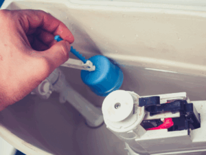 Plumber adjusting toilet fill valve