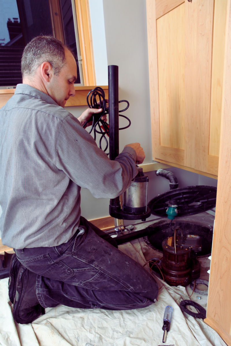 Plumber testing sump pump in Birmingham home